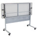A speckled gray NPS Mobile Flip Top Table on wheels.