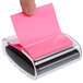 A hand using a 3M Post-it Pop-Up Notes dispenser to hold a pink sticky note.