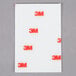 A white rectangular 3M Scotch clear mounting strip package with red and black text.