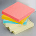 A stack of 3M Post-It notes in assorted colors on a counter.