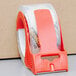 A roll of 3M Scotch heavy-duty packaging tape with a red handle on the dispenser.