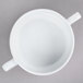 An Arcoroc white porcelain soup bowl with two handles.
