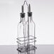 A Choice 3 piece oil and vinegar cruet set with metal racks holding two clear glass bottles with metal spouts.