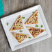 An Elite Global Solutions white rectangular melamine serving platter with a slice of pizza on it.