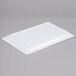 A white rectangular melamine serving platter on a gray surface.