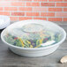 A close up of a white Fineline low profile plastic catering bowl with a lid.