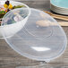A Fineline clear plastic catering bowl filled with salad with a clear plastic lid on top.