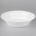 A Fineline white low profile plastic catering bowl on a gray surface.