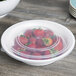 A Fineline white plastic low profile catering bowl filled with strawberries.