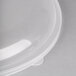 A close-up of a clear plastic Fineline Catering Bowl with a clear plastic lid.
