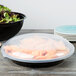 A table with a Fineline black low profile plastic catering bowl filled with salad.