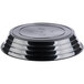 A stack of black Fineline low profile plastic bowls with a lid on top.