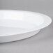 A close-up of a Fineline white high rim plastic catering tray on a gray surface.