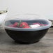 A close up of a Fineline black high profile plastic catering bowl filled with strawberries.