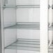 A white Avantco refrigerator with shelves inside.