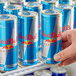 A person's hand holding a close-up of a Red Bull Sugar Free Energy Drink can.