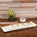An American Metalcraft curved edge porcelain serving platter with sushi rolls on it.