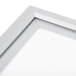 The corner of a white Aarco aluminum slide frame with a metal border.