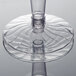 A close-up of a clear Fineline plastic wine goblet with a stem and circular base.