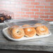 A clear plastic Eco-Products lid on a disposable serving tray with bagels inside.