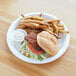 A white Eco-Products compostable sugarcane plate with a burger and fries on it.