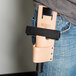 A person wearing a Unger leather holster for window cleaning tools on their jeans.