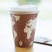 An Eco-Products compostable plastic hot cup lid on a coffee cup with a map on it.