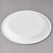 A Eco-Products white compostable sugarcane plate on a gray surface.