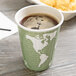 A close up of a Eco-Products World Art insulated hot cup full of coffee with a map of the world on it.