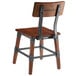 A Lancaster Table & Seating Rustic Industrial dining side chair with metal legs and a wooden seat.