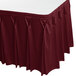 A burgundy Snap Drape table skirt with pleated pleats on a table.