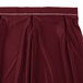 A burgundy Snap Drape table skirt with pleats and white stitching.