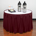 A table with a burgundy Snap Drape table skirt with Velcro clips on it.