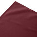 A burgundy Snap Drape table skirt with shirred pleats.
