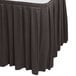 A Snap Drape Wyndham charcoal table skirt with pleated edges on a table.