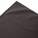 A charcoal box pleat table skirt on a table with velcro clips.