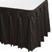 A black table skirt with white bow tie pleats on a table.