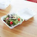 A salad in a white Eco-Products compostable takeout container.
