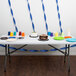 A table with a navy blue streamer and a cake on it.