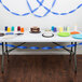 Cobalt blue paper streamers on a table with a white cake and cups.