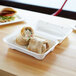 A sandwich and a wrap in a white Eco-Products compostable takeout container.