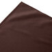 A brown Snap Drape table skirt with a shirred pleat design on a table with a white tablecloth.