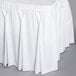 A white Snap Drape Wyndham table skirt with pleated edges on a table.