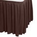 A brown box pleat table skirt on a table.