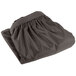 A folded charcoal table skirt with a shirred pleat design.