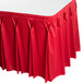 A red table skirt with pleated bow tie edges.