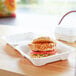 A sandwich in a white Eco-Products compostable takeout container.