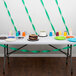 A table with a Hunter Green Streamer Paper-covered cake and cups on it.