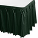 A jade green table skirt with bow tie pleats and velcro clips on a table.
