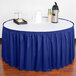 A table with a royal blue Snap Drape Wyndham table skirt on it.